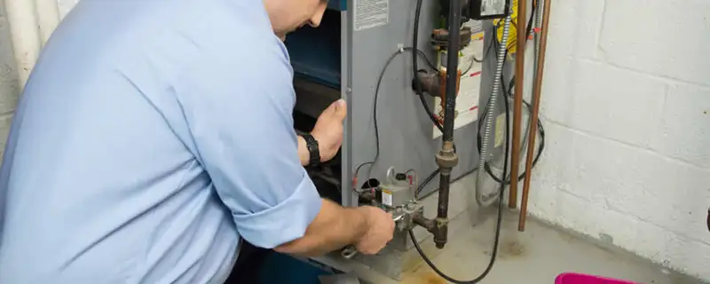 Furnace repair technician inspecting and servicing a home heating system in Tulsa, OK