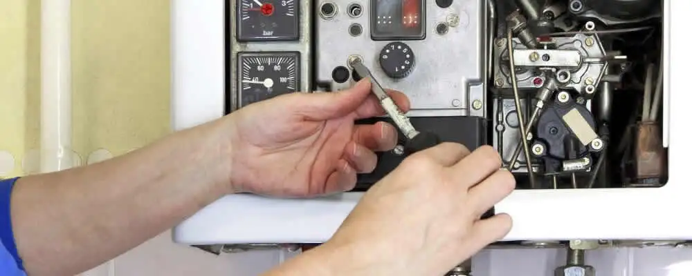 Heating repair technician adjusting boiler controls and components in Tulsa, OK