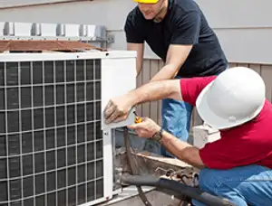 HVAC technicians repairing an outdoor AC unit on a rooftop in Tulsa, OK