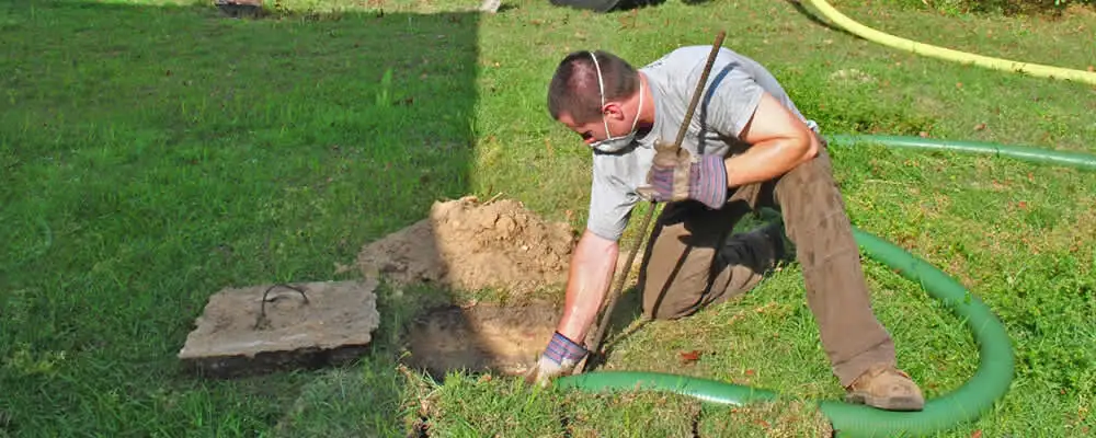 Septic pumping technician servicing a residential septic tank in Tulsa, OK