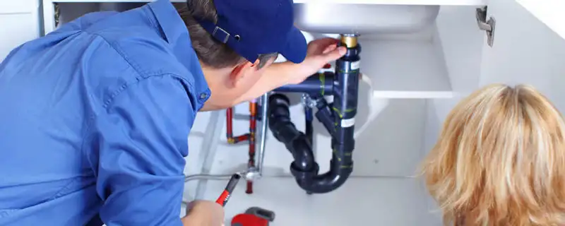 Plumber repairing under-sink drain pipes and fittings in Tulsa, OK
